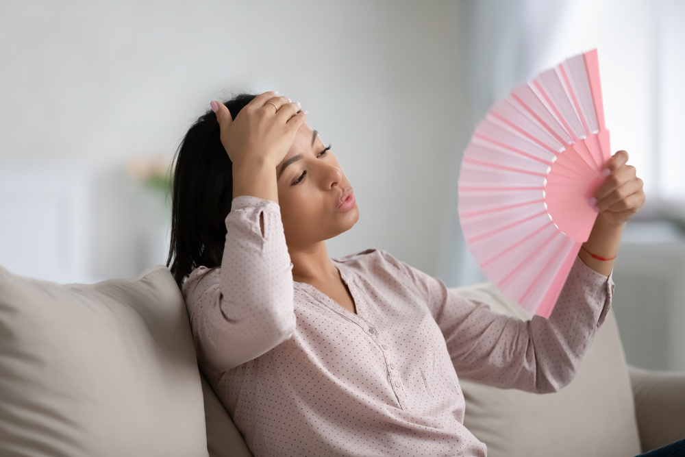 Woman Fans Herself As Her AC Struggles This Summer